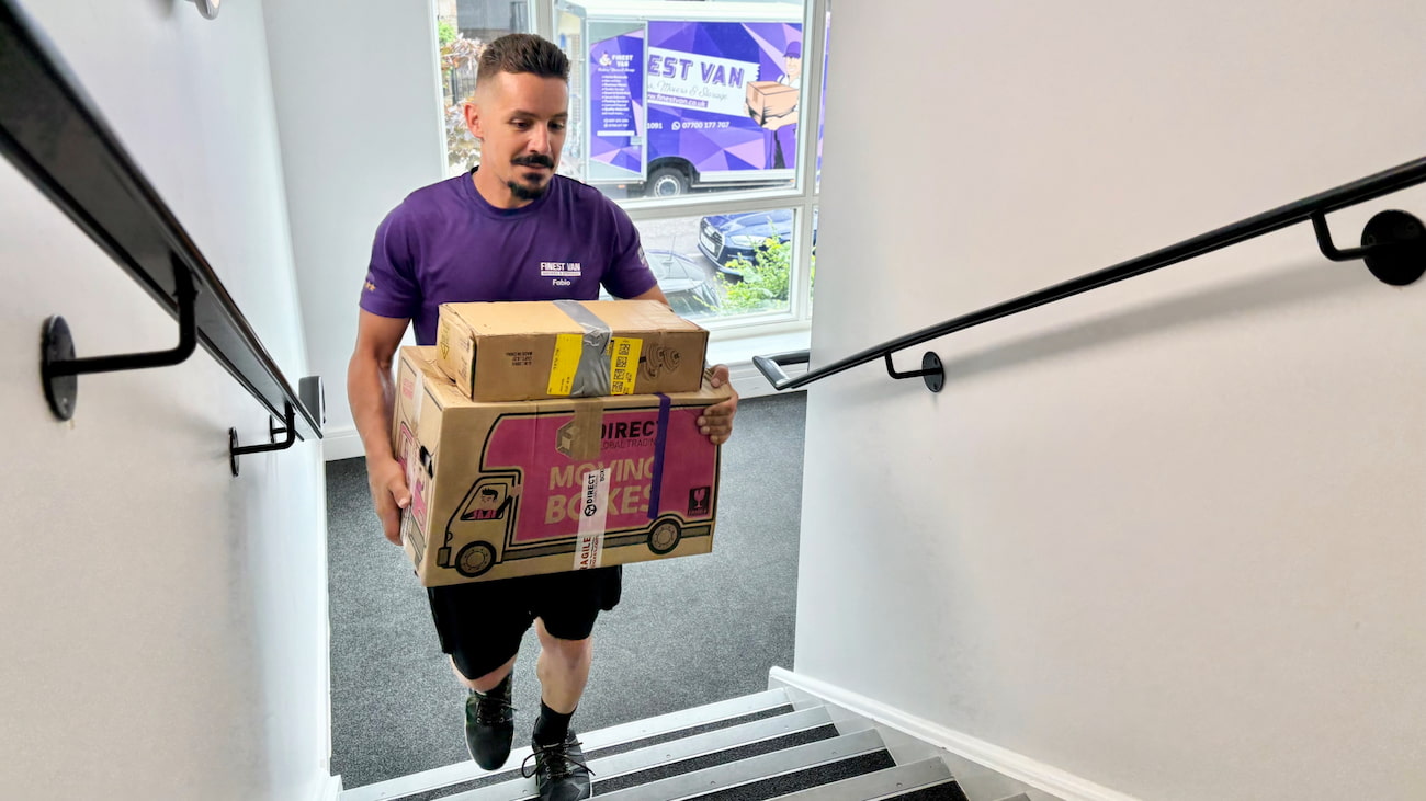 Removal specialist carrying a box upstairs during a London house move