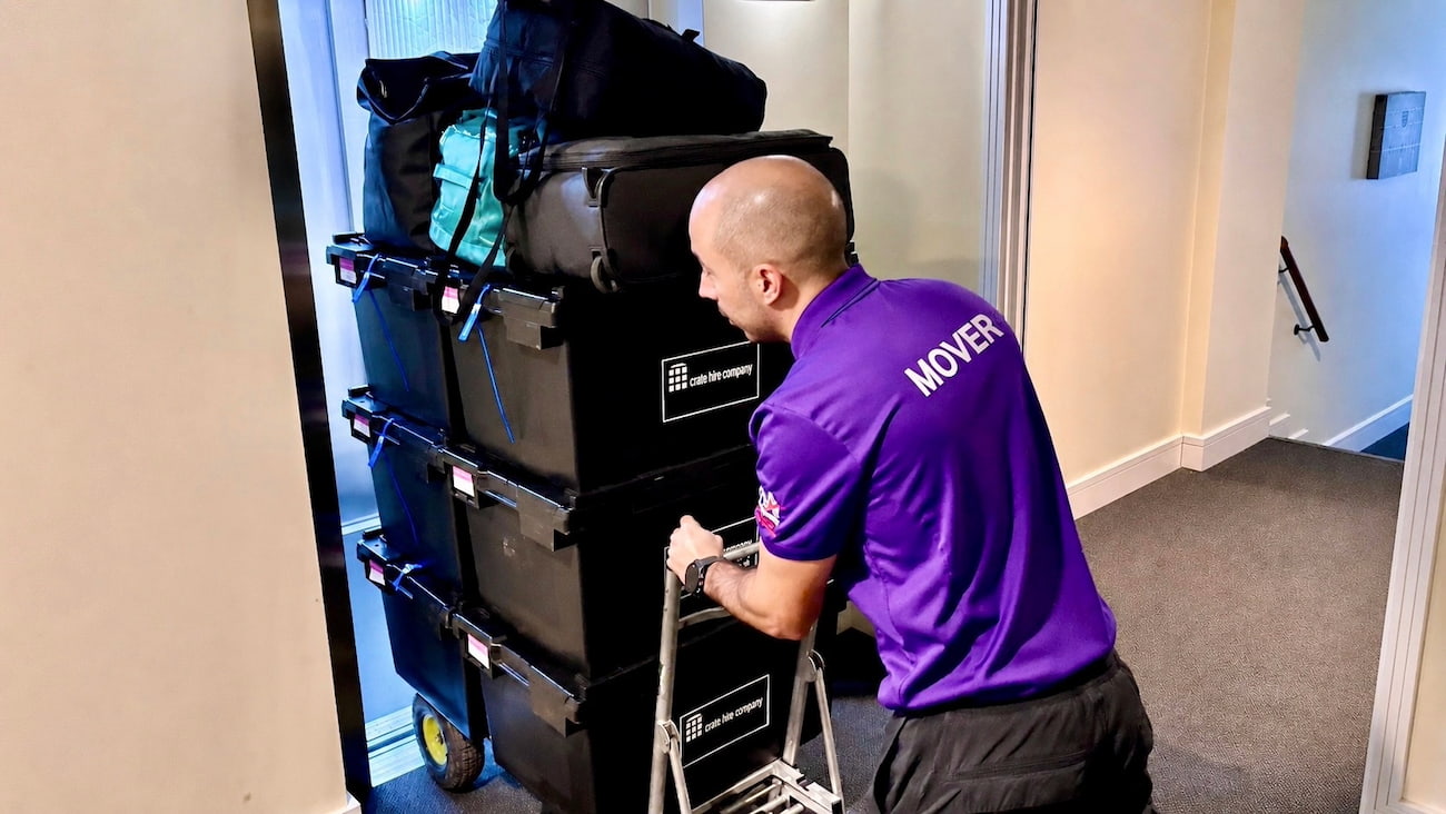 Removals specialist pushing a trolley with office crates during a business move