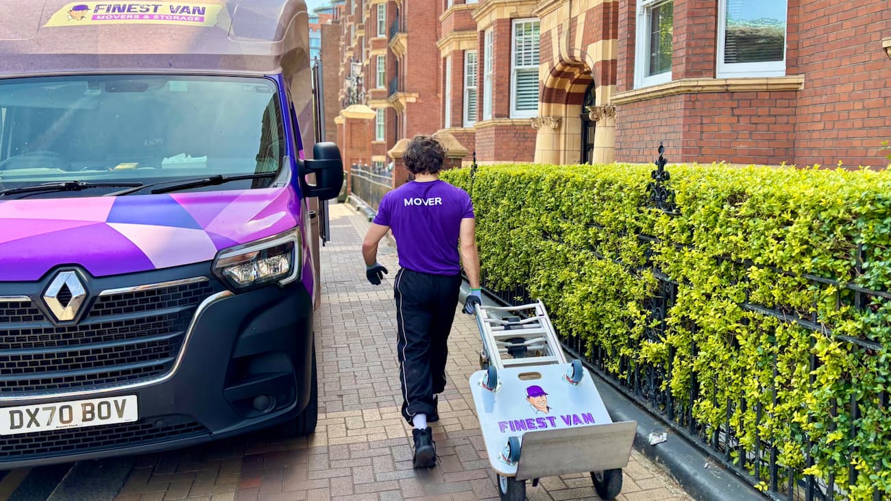 Removals specialist wheeling a trolley beside a Finest Van van outside student halls