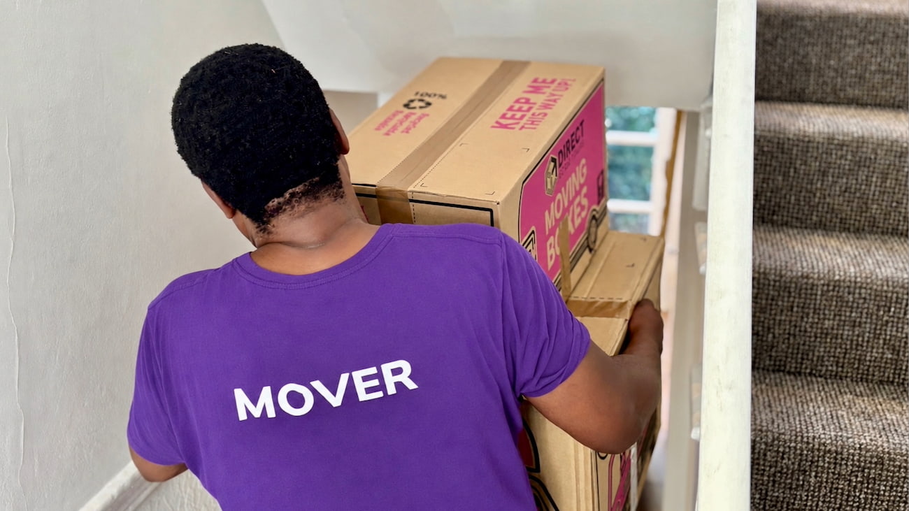 Finest Van removals specialist carrying packed boxes into a property during a house move