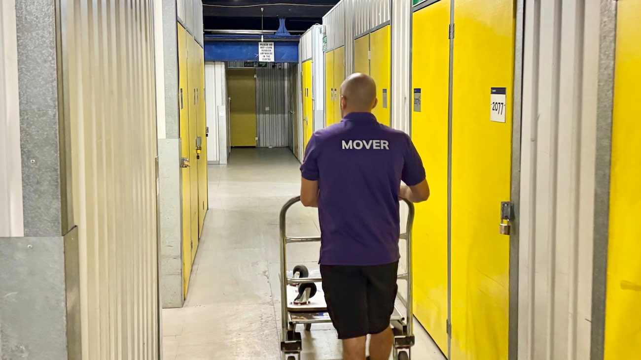 Finest Van removals specialist pushing an empty trolley after unloading belongings at a self storage facility