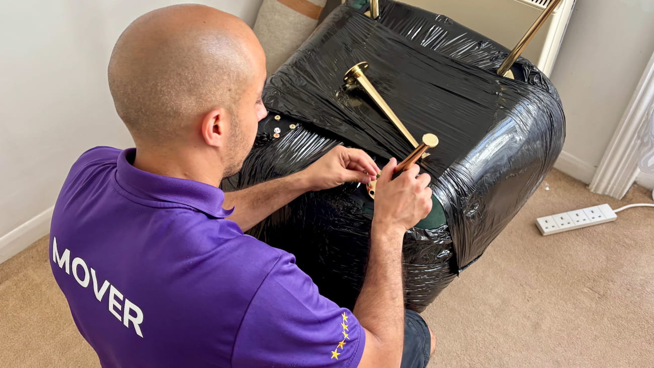 Removal specialist assembling chair legs during a student move in London