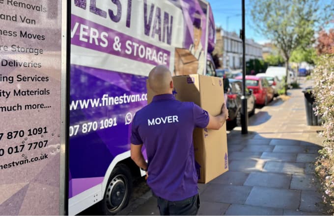 Removal specialist helping with a university move in London Removal specialist carrying a box towards a London property during a university move