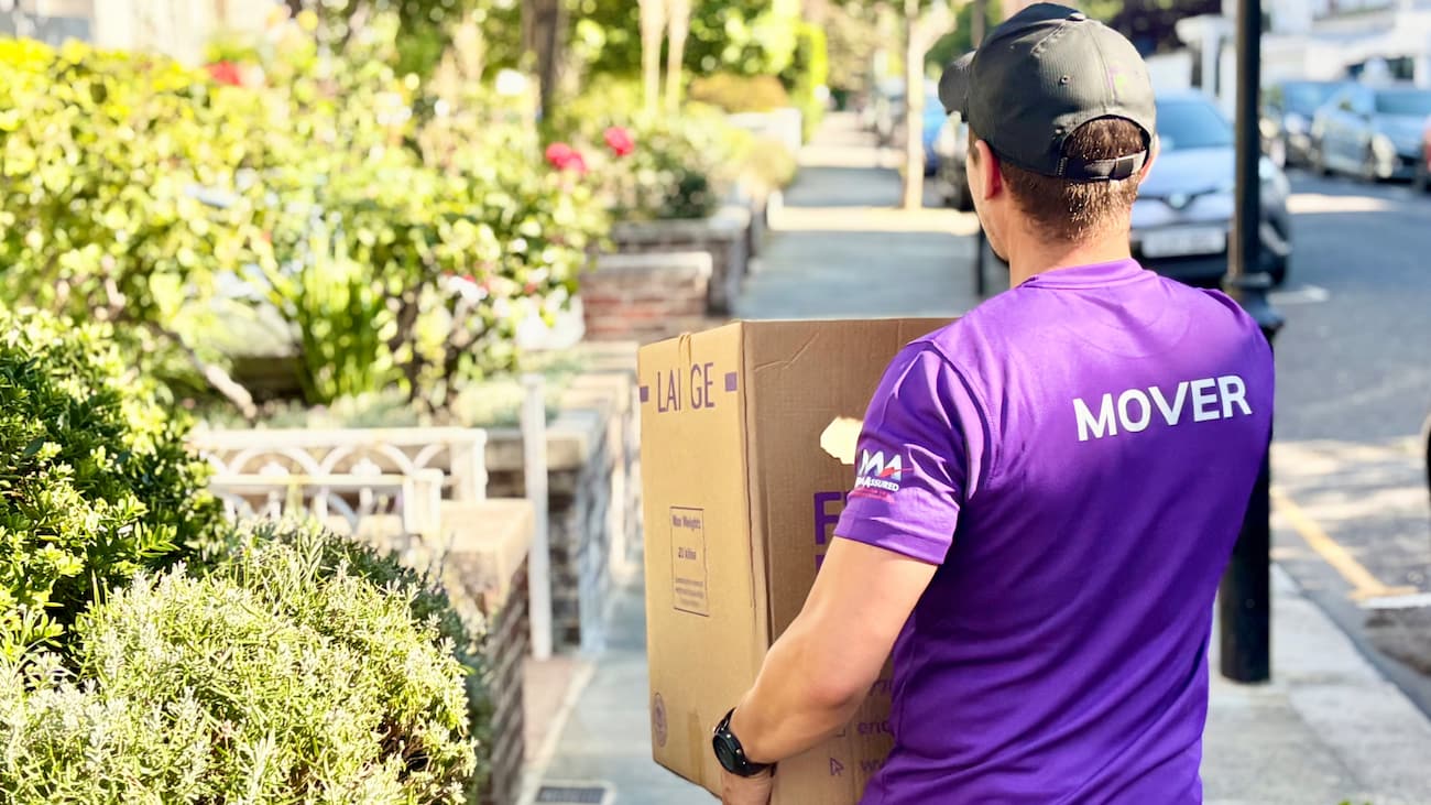 Finest Van removals specialist carrying a packed box during a house move