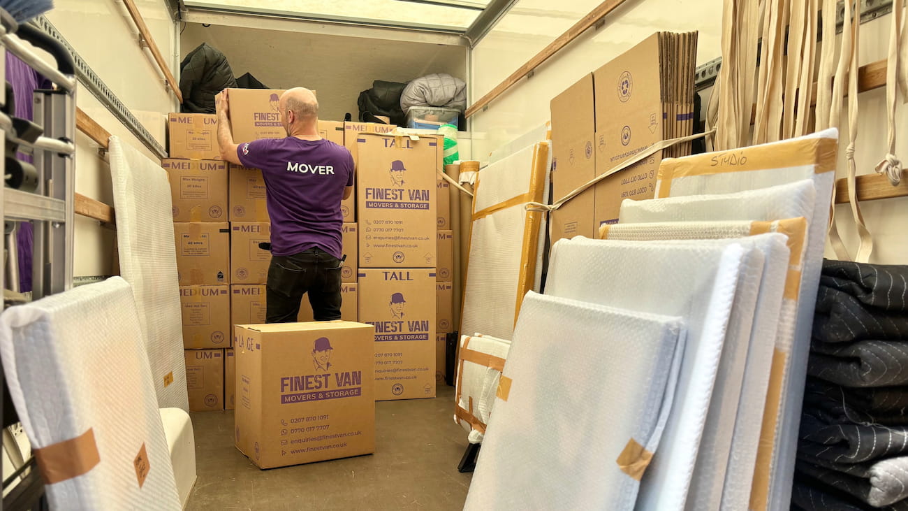 Finest Van removal specialist loading boxes into a van during a London house move