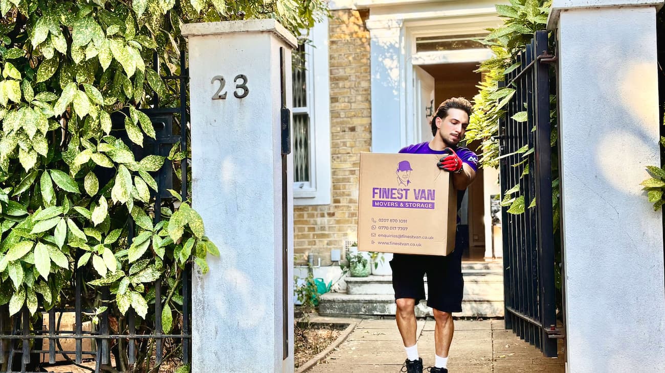Finest Van removal specialist carrying a box during a house move