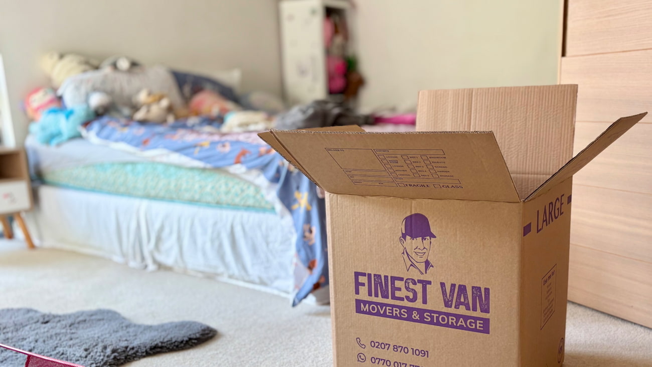 Open moving box in a student bedroom while packing for a London student move