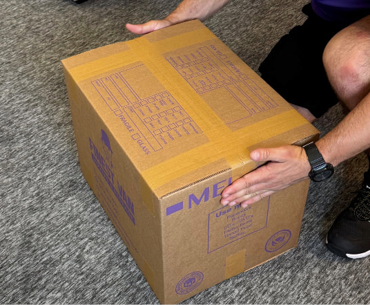 Finest Van removals specialist securing the top of a moving box using the H-taping method