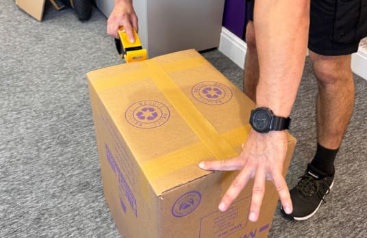 Finest Van removals specialist securing the base of a moving box using the H-taping method