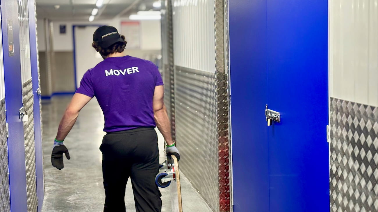 Finest Van removals specialist carrying moving equipment inside a London storage facility